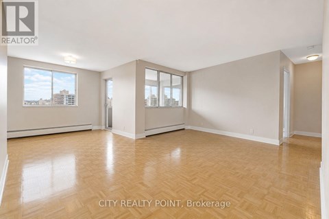 A spacious room with wooden flooring and large windows at City Realty Point, Brokerage.