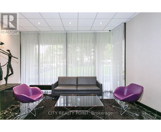 A living room with a black couch, purple chairs, and a glass table.