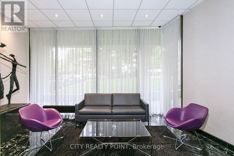 A living room with a black couch, purple chairs, and a glass table.