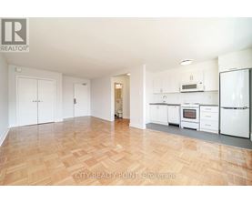 A kitchen with white appliances and wooden floors.