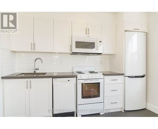 A white kitchen with a microwave above the stove.