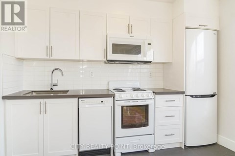 A white kitchen with a microwave above the stove.