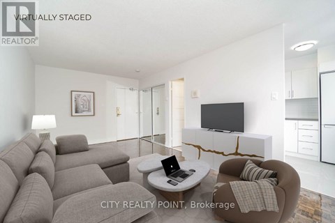 A modern living room with a grey sofa and a television.