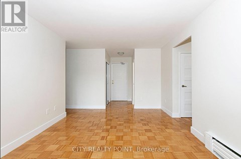 A room with wooden flooring and white walls.