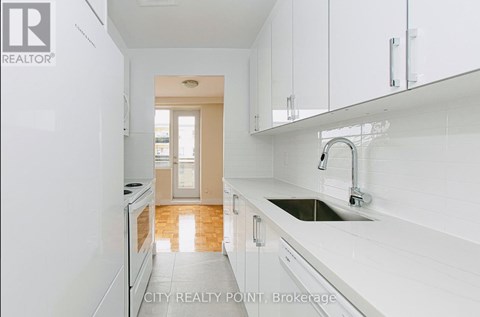 A kitchen with white cabinets and a sink.