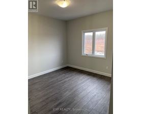 A room with a window and wooden flooring.