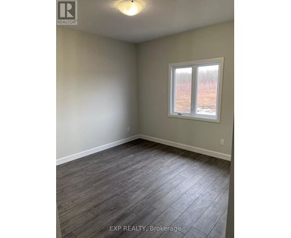 A room with a window and wooden flooring.