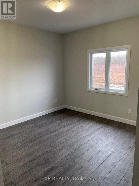 A room with a window and wooden flooring.