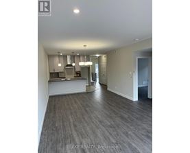 A real estate listing photo of a kitchen and living room.