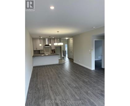 A real estate listing photo of a kitchen and living room.
