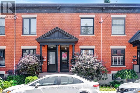 A red brick building with a black door and windows.