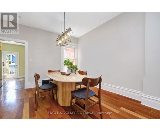A dining room with a round table and chairs.
