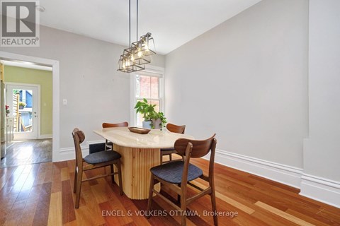 A dining room with a round table and chairs.