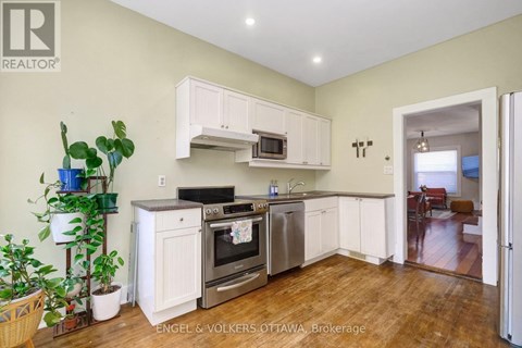 A kitchen with white cabinets and stainless steel appliances.
