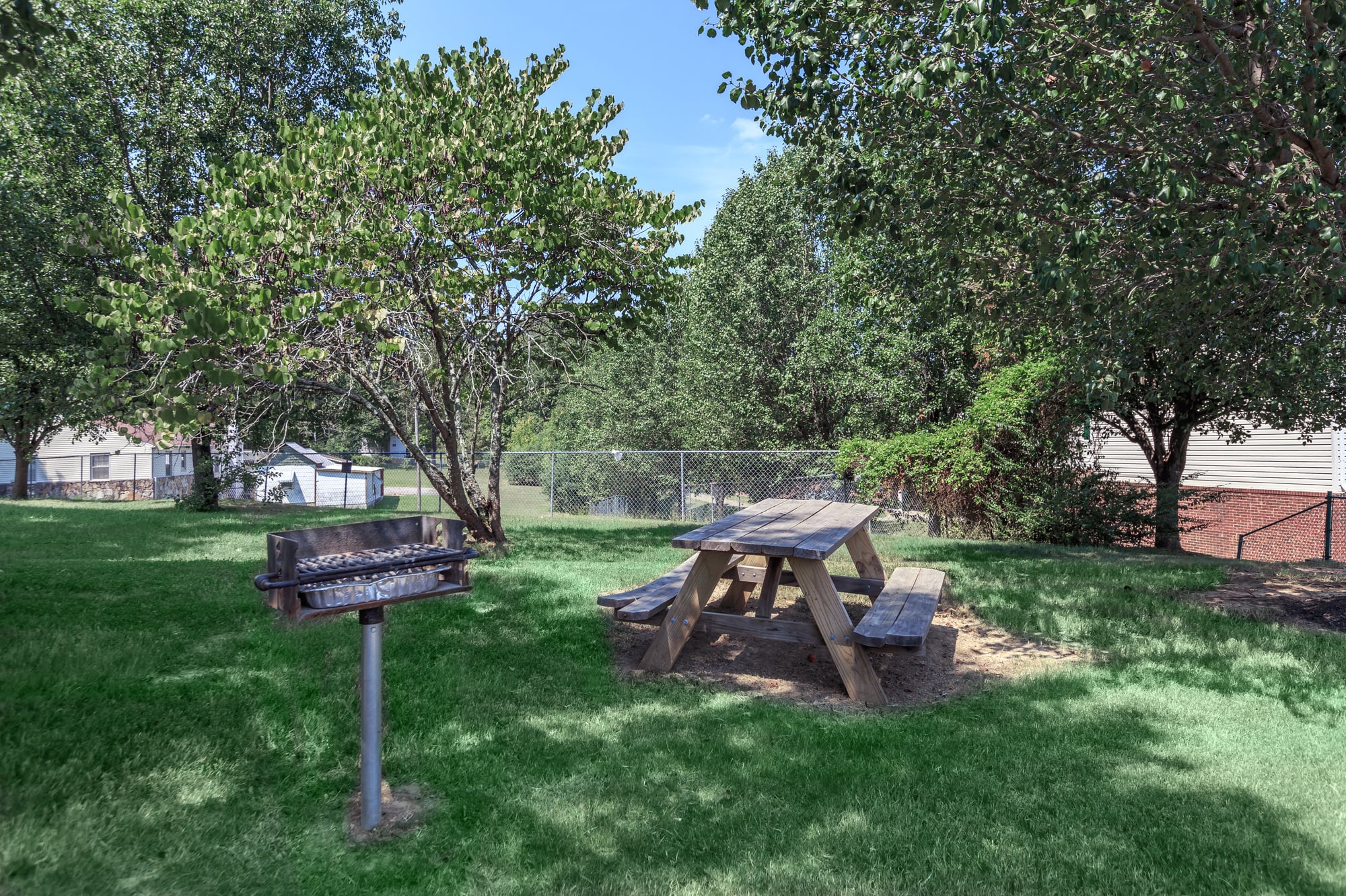 Madison Ridge Apartments Outdoor Grilling Area with wooden table and bench seating