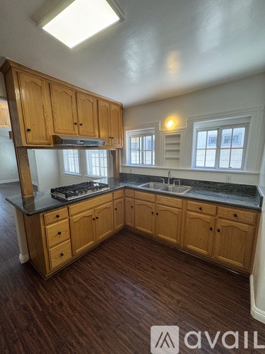A kitchen with wooden cabinets and a black countertop.