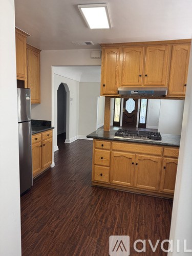 A kitchen with wooden cabinets and a stainless steel refrigerator.