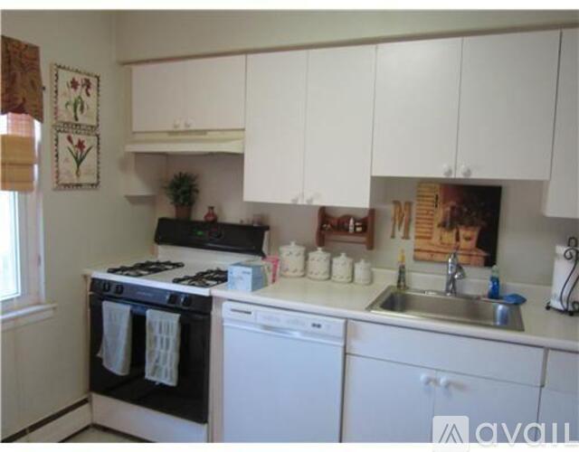 A kitchen with white cabinets and appliances.