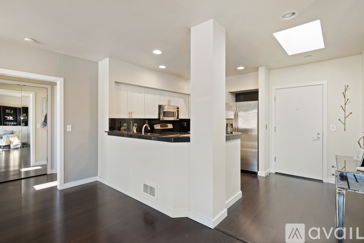 A modern kitchen with white cabinets and a black countertop.