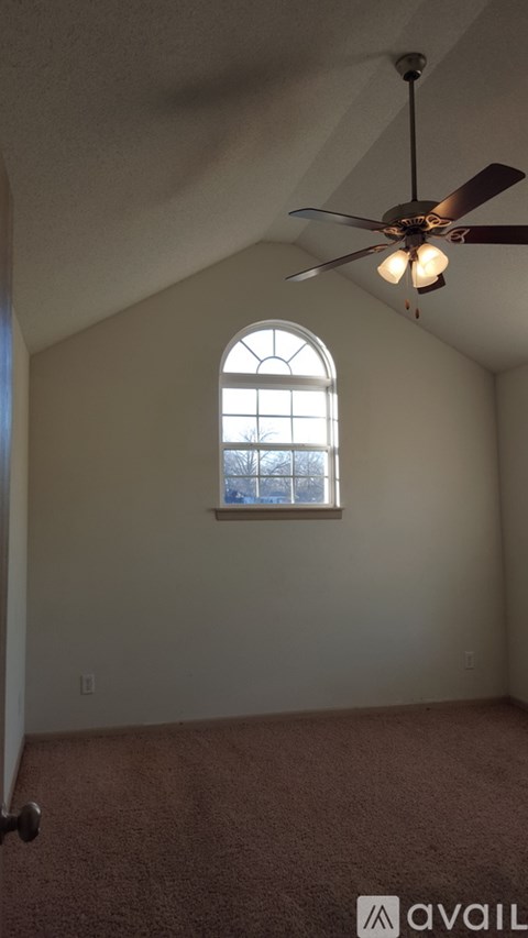 A room with a ceiling fan and a window.