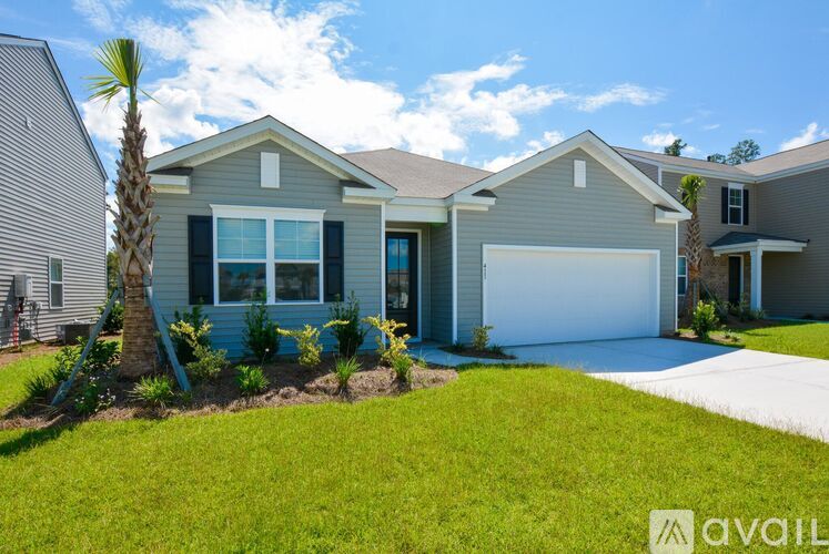A house with a blue garage door and a palm tree in front.