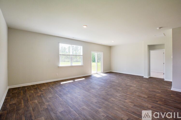 A room with wooden flooring and a window.