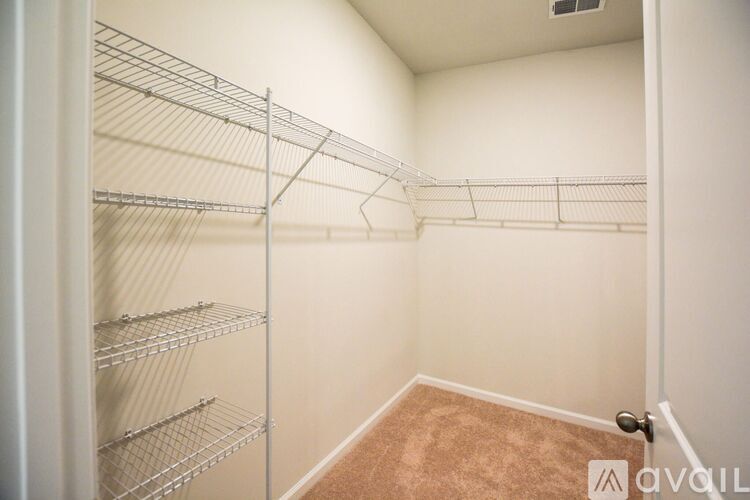 Empty walk-in closet with shelving and a door.