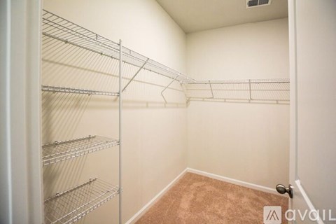 Empty walk-in closet with shelving and a door.