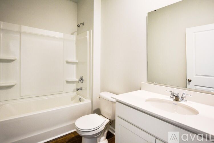 A white bathroom with a toilet, sink, and bathtub.