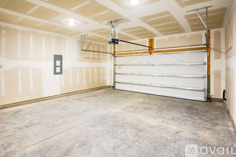 A garage with a white door and a grey floor.