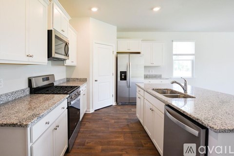 A kitchen with white cabinets and a granite countertop.