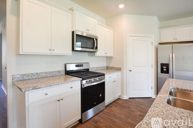 A kitchen with white cabinets and a granite countertop.