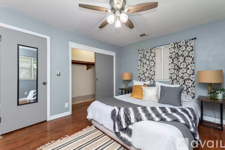 A bedroom with a bed, a ceiling fan, and a rug.