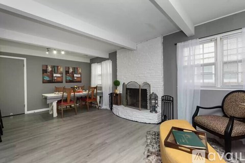 A living room with a fireplace and a dining table.