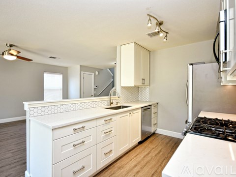 A kitchen with white cabinets and a white stove top oven.
