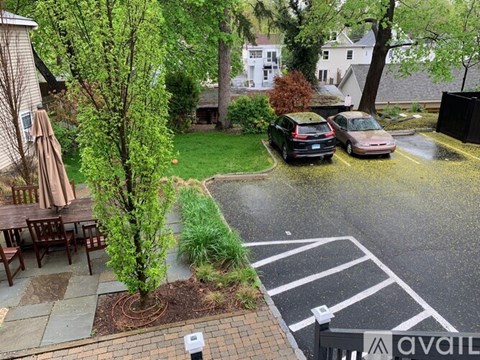 A parking lot with two cars and a rain shower.