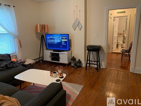 A living room with a television on a stand and a couch.