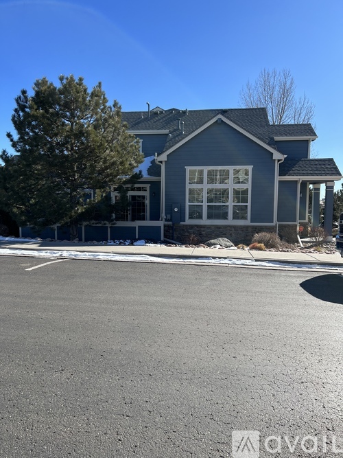 A house with a blue exterior and a large front yard.