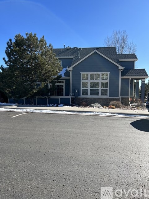A house with a blue exterior and a large front yard.