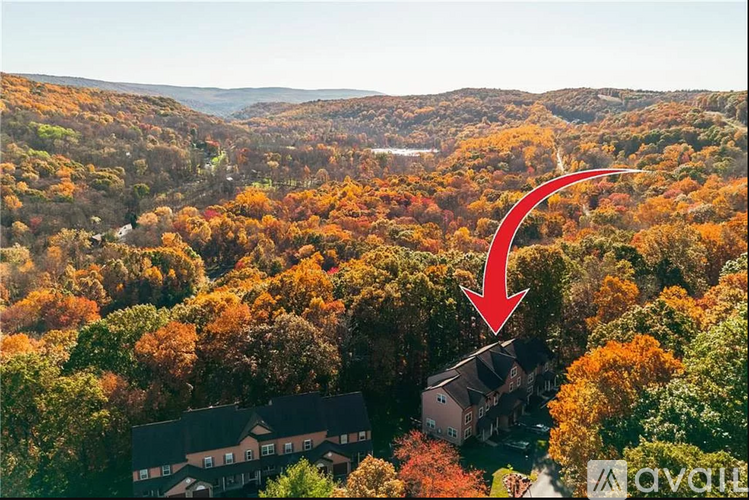 A red arrow points to a house surrounded by trees in a forest.