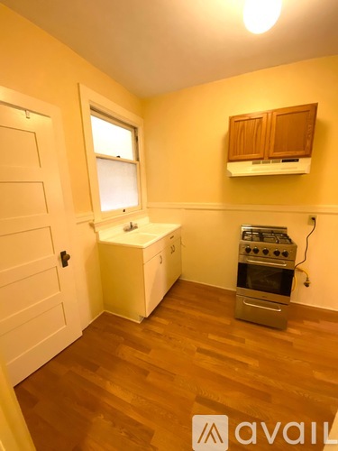 A kitchen with wooden floors and a stove top oven.