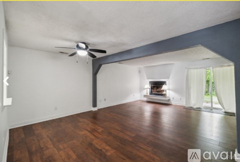 A room with a fireplace and a ceiling fan.