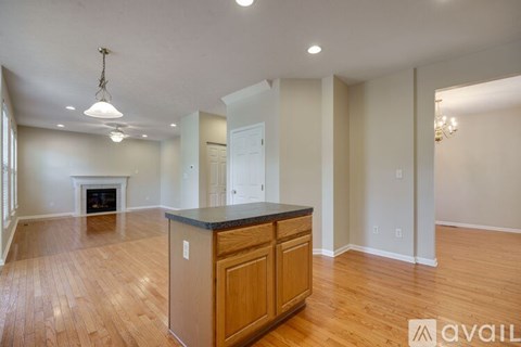 A spacious kitchen with wooden cabinets and a black countertop.