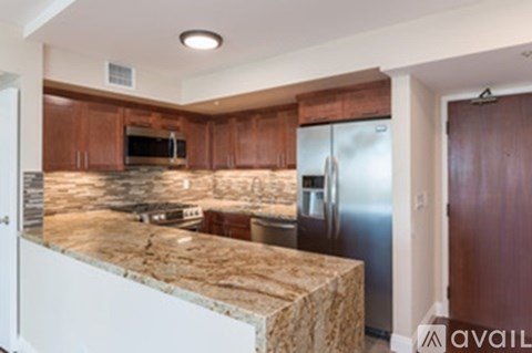 A kitchen with a granite counter top and stainless steel appliances.