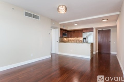 A spacious living room with hardwood floors and a large window.