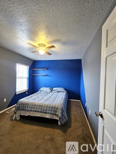 A bedroom with a bed and a ceiling fan.