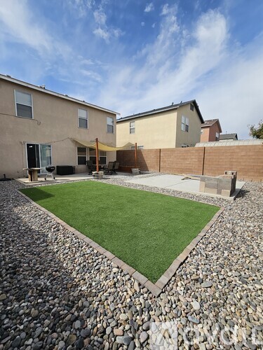 A backyard with a grassy area and a gravel path.