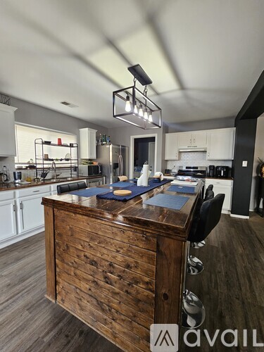 A kitchen with a wooden counter and a black chair.
