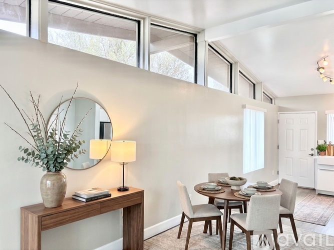 A dining room with a round table and chairs.