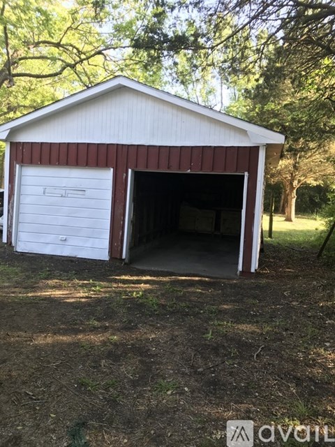 A white garage with a red stripe on the side is open.